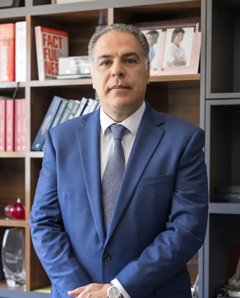 Retrato de Alfredo Scaff Filho diante da estante de livros